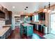 Modern kitchen with dark cabinets, granite countertops, a center island, and stainless steel appliances at 18995 E Bellisario Creek Pl, Parker, CO 80134