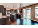 Open kitchen with dark wood cabinets, a granite island, and a sliding glass door to the backyard at 18995 E Bellisario Creek Pl, Parker, CO 80134