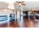 Spacious living room with a fireplace, a large television, and an open view to the kitchen at 18995 E Bellisario Creek Pl, Parker, CO 80134