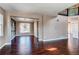 Open-concept living area with hardwood floors, wood accent wall, and a view into dining area; airy and bright at 18995 E Bellisario Creek Pl, Parker, CO 80134