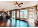 Bright living room with dark wood floors, large windows, and an open view to the kitchen at 18995 E Bellisario Creek Pl, Parker, CO 80134