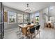 Cozy dining room with a rustic table, modern chandelier, and views of the backyard at 9375 Joyce Way, Arvada, CO 80007