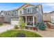 Beautiful two-story home with stone accents, a covered porch, landscaped garden, and a two-car garage at 9375 Joyce Way, Arvada, CO 80007