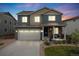 Charming two-story home featuring a well-maintained lawn, covered porch, and attached two-car garage at 9375 Joyce Way, Arvada, CO 80007