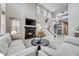 Bright, open-concept living space featuring a fireplace, a staircase, and comfortable seating at 9375 Joyce Way, Arvada, CO 80007