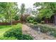 Serene backyard with a stone pathway, mature trees, and lush landscaping, creating a private oasis at 6687 Devinney Ct, Arvada, CO 80004