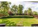 Well-manicured backyard featuring lush greenery, a stepping stone pathway, and mature trees for privacy at 6687 Devinney Ct, Arvada, CO 80004