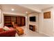 Cozy basement area featuring built-in shelving, a comfortable seating area, and an electric fireplace at 6687 Devinney Ct, Arvada, CO 80004