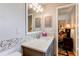 Bathroom with modern vanity, neutral mosaic tiles and view of primary bedroom at 6687 Devinney Ct, Arvada, CO 80004