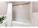 Clean bathroom showcasing white tiled walls and a bathtub with shower curtain, offering a fresh, simple design at 6687 Devinney Ct, Arvada, CO 80004