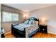 Cozy bedroom with hardwood floors, natural light, and a comfortable bed with stylish linens at 6687 Devinney Ct, Arvada, CO 80004