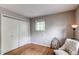 Bedroom featuring hardwood floors, a comfortable chair, large closet, and plenty of natural light at 6687 Devinney Ct, Arvada, CO 80004