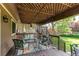 Inviting covered deck with a lattice ceiling, stylish furniture, curtains, and access to a beautifully landscaped backyard at 6687 Devinney Ct, Arvada, CO 80004