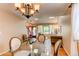 Open-concept dining area with hardwood floors, chandelier lighting and large windows at 6687 Devinney Ct, Arvada, CO 80004