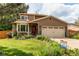 Charming two-story home with a well-maintained lawn and colorful landscaping, a two car garage, and stone accents at 6687 Devinney Ct, Arvada, CO 80004