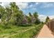 Scenic view of a green space with mature trees, lush vegetation, and a paved pathway for outdoor recreation at 6687 Devinney Ct, Arvada, CO 80004