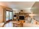 Cozy living room features a stone fireplace, hardwood floors, and sliding glass doors to the deck at 6687 Devinney Ct, Arvada, CO 80004