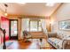 Bright living room with hardwood floors, large windows, and a welcoming red front door at 6687 Devinney Ct, Arvada, CO 80004