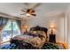 Main bedroom suite with balcony access, ceiling fan, and dark wood furniture at 6687 Devinney Ct, Arvada, CO 80004