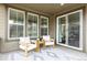 Covered back porch featuring comfortable armchairs and sliding glass door access to the home at 8175 Sewanee Peak St, Littleton, CO 80125