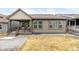 Back exterior with a covered porch and well-lit windows, overlooking a grassy yard at 8175 Sewanee Peak St, Littleton, CO 80125