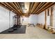 Unfinished basement featuring visible ceiling pipes, concrete floor, and white tarp walls with workout equipment at 8175 Sewanee Peak St, Littleton, CO 80125