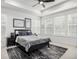 Comfortable bedroom with a tray ceiling, large windows, modern decor, and plush rug at 8175 Sewanee Peak St, Littleton, CO 80125