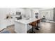 Bright kitchen featuring white cabinetry, quartz countertops, and a stylish breakfast bar at 8175 Sewanee Peak St, Littleton, CO 80125
