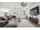 Bright living room with a leather sofa, large windows, modern decor, and a ceiling fan at 8175 Sewanee Peak St, Littleton, CO 80125