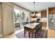 Bright dining area with sliding glass doors, hardwood floors, and a rustic wooden table with seating for six at 7999 S Blackstone Pkwy, Aurora, CO 80016