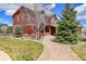 Charming front yard featuring a well-manicured lawn, mature evergreens, and a brick walkway leading to the entrance at 7999 S Blackstone Pkwy, Aurora, CO 80016