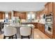 Well-lit kitchen featuring custom cabinets, stainless steel appliances, granite countertops, and hardwood flooring at 7999 S Blackstone Pkwy, Aurora, CO 80016