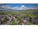 Scenic aerial view of a community nestled among lush trees, with mountains in the distance, showcasing natural beauty at 10735 W Dartmouth Ave, Lakewood, CO 80227