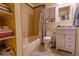 This cozy bathroom features a tiled shower-tub, open shelves, and vanity at 10735 W Dartmouth Ave, Lakewood, CO 80227