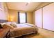 This bedroom features a neutral color palette, window and closet at 10735 W Dartmouth Ave, Lakewood, CO 80227