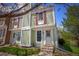 Charming townhome featuring a light green exterior, red shutters and well-maintained landscaping at 10735 W Dartmouth Ave, Lakewood, CO 80227