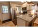Updated kitchen with stainless steel appliances, white cabinets, and peninsula counter at 10735 W Dartmouth Ave, Lakewood, CO 80227