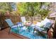 Outdoor patio offering a cozy seating area, privacy fence, and lush greenery at 10735 W Dartmouth Ave, Lakewood, CO 80227