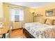 Inviting bedroom featuring hardwood floors, a cozy bed with decorative pillows, and a bright window at 12089 W Chenango Dr, Morrison, CO 80465