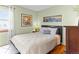 Comfortable bedroom featuring a bed, hardwood floors, artwork, and ample natural light at 12089 W Chenango Dr, Morrison, CO 80465