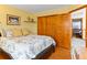Sunny bedroom with a large bed, hardwood floors, and a closet with wood doors at 12089 W Chenango Dr, Morrison, CO 80465
