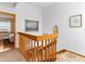 Upstairs hallway with wooden railings, artwork, and a glimpse into a bedroom at 12089 W Chenango Dr, Morrison, CO 80465