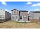 Back exterior of a two-story home featuring solar panels, a patio, and a partially fenced yard for outdoor living at 432 N Patsburg St, Aurora, CO 80018