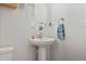 Stylish powder room with a pedestal sink, modern fixtures, and a decorative mirror at 432 N Patsburg St, Aurora, CO 80018