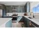 Modern kitchen with sleek dark green cabinetry, stainless steel appliances, and quartz countertops at 432 N Patsburg St, Aurora, CO 80018