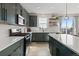 Stylish kitchen with modern green cabinets, stainless appliances, quartz counters, and tile backsplash at 432 N Patsburg St, Aurora, CO 80018