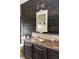 Bathroom with a rustic vanity, an ornate mirror, a decorative wall light, and wood plank accent wall at 185 Players Club Dr, Castle Rock, CO 80104