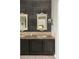 Bathroom featuring a vanity with double sinks, framed mirrors, rustic wall lighting, and neutral accents at 185 Players Club Dr, Castle Rock, CO 80104