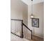Staircase featuring a black banister, soft carpet, and stylish pendant light at 185 Players Club Dr, Castle Rock, CO 80104