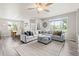Bright living room with gray sectional, large windows, ceiling fan, and stylish decor at 11684 Park South Loop, Parker, CO 80138
